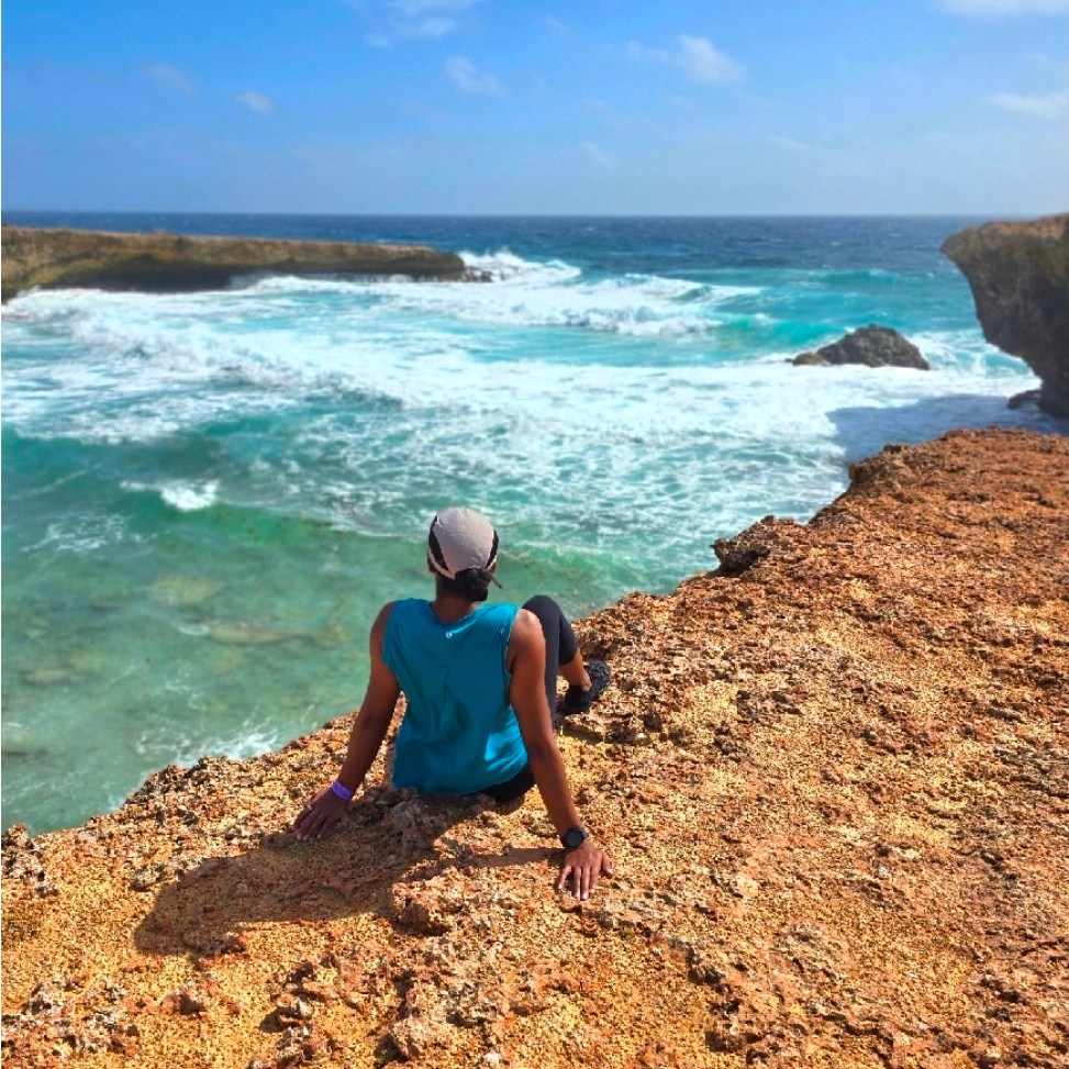Woman sitting, overlooking Boca Prins Beach in Aruba.
