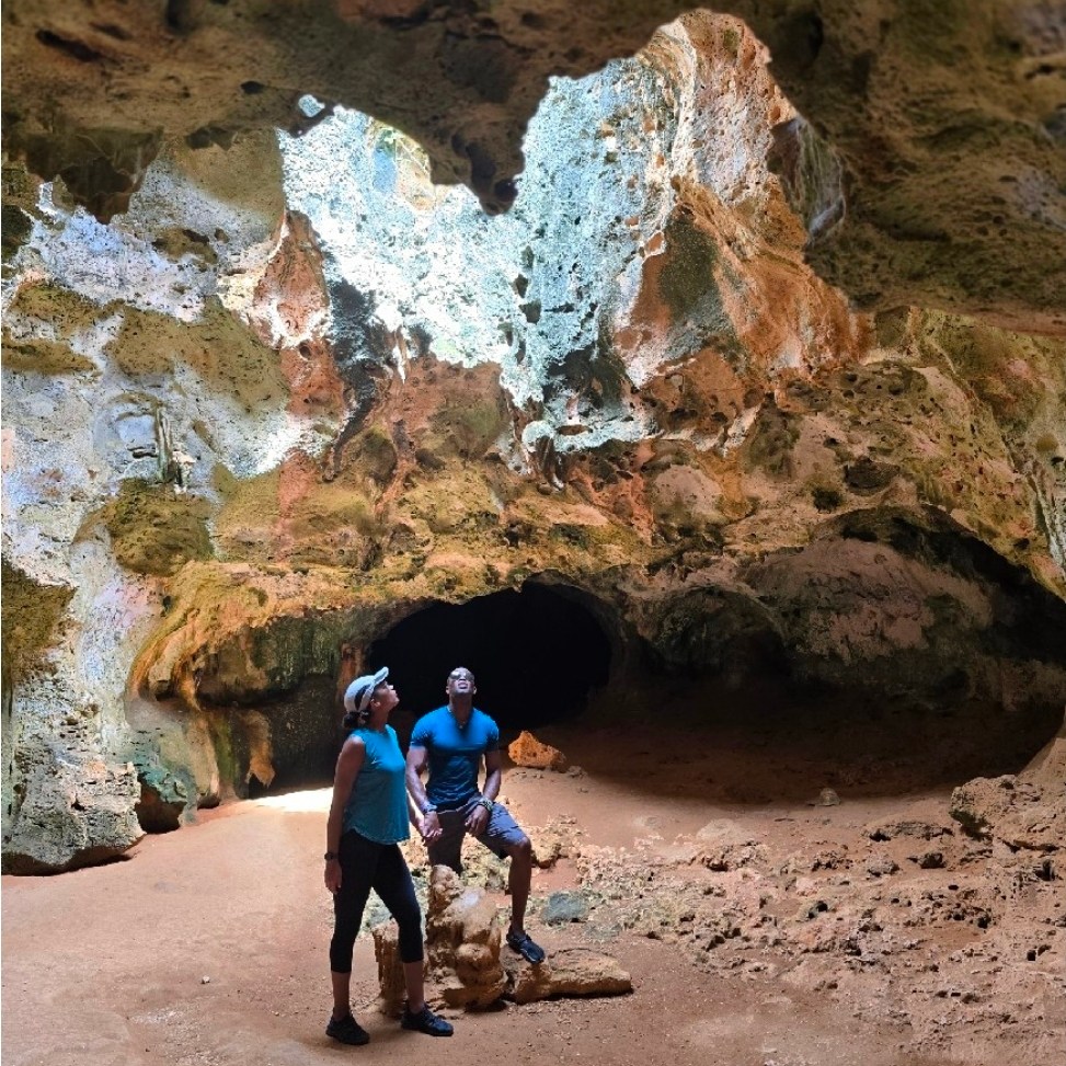 Man and woman holding hands in a Quadirikiri Cave in the Arikok National Park in Aruba.